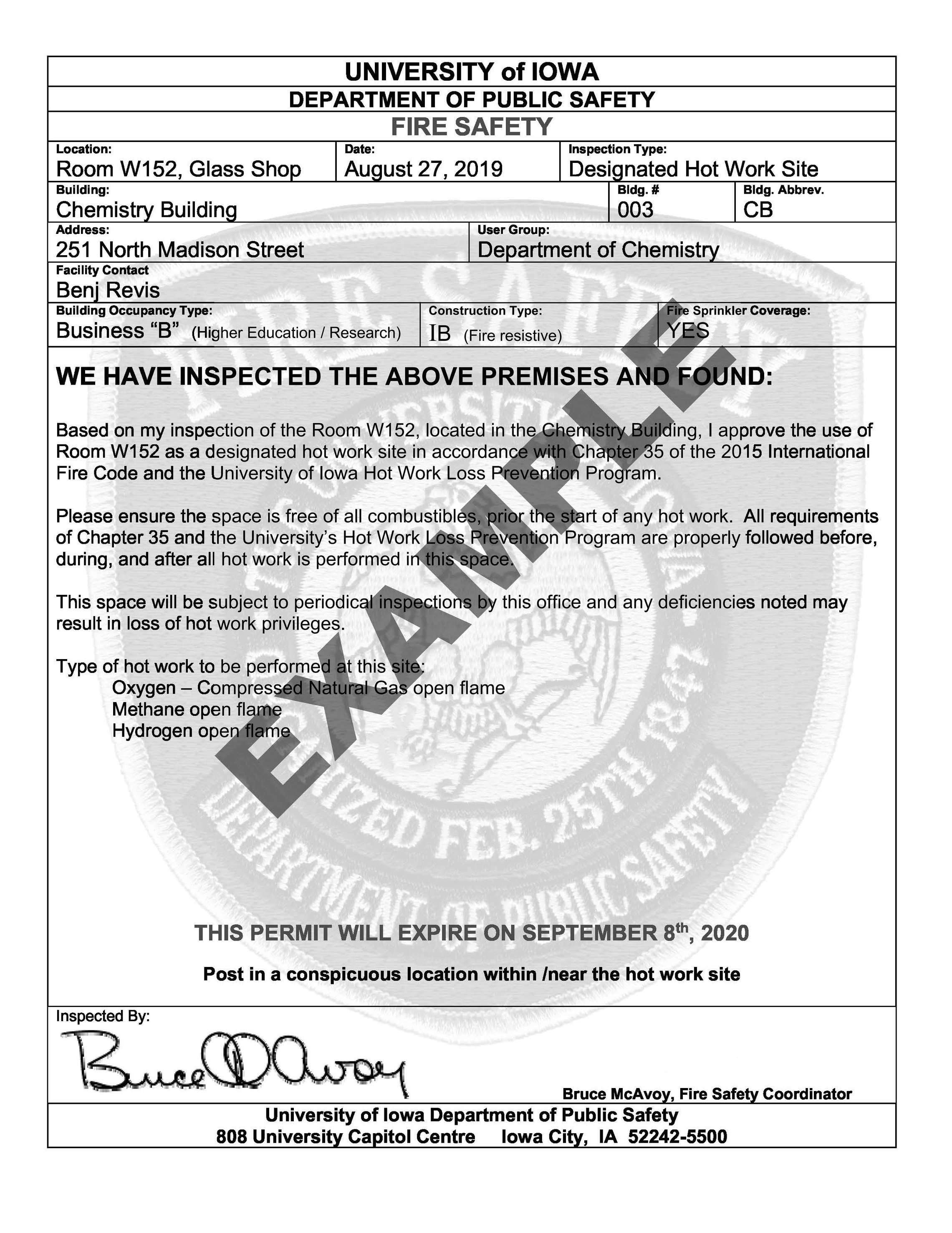 An example of a University of Iowa Department of Public Safety “Designated Hot Work Site” permit. The sample form shows a completed inspection for Room W152 Glass Shop in the Chemistry Building, listing inspection details, approved hot‑work types, safety requirements, an expiration date, and an inspector’s signature. The document is intended to be posted near the designated hot‑work site.